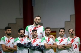 Morteza Mehrzad towers over his teammates in Iran's sitting volleyball team