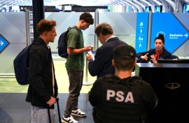 French rugby players Oscar Jegou (L) and Hugo Auradou (2nd L) and their lawyer Rafael Cuneo Libarona (3rd R), wait before taking a flight to France at the Ezeiza International Airport, Buenos Aires