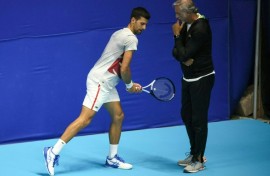 Italian fitness coach Marco Panichi (R) working with Serbia's Novak Djokovic during the 2022 Tel Aviv Open