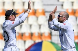 England's captain Ollie Pope celebrates with teammate Jack Leach (R) after winning the first Test cricket match against Pakistan 