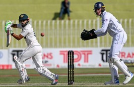 Pakistan's Saud Shakeel (L) plays a shot as England's wicketkeeper Jamie Smith looks on during the second day of the third and final Test