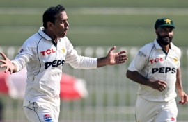 Pakistan's Noman Ali (L) celebrates after taking the wicket of England's captain Ben Stokes 