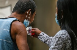 A man spits a sputum sample during a tuberculosis screening at a health centre in Valenzuela in the Philippines
