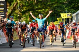 One last wave: Mark Cavendish (C) celebrates as he crosses the line to win his farewell race, the  Singapore Criterium 