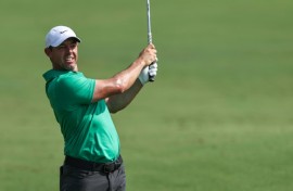 Out in front: Rory McIlroy eyes the ball after playing a shot on the first hole 