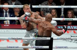 Jake Paul (left) backs Mike Tyson onto the ropes in their eight-round fight in Texas on Friday