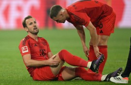 Bayern Munich forward Harry Kane (L) grabs his injured hamstring before being subbed off in Saturday's 1-1 draw with Borussia Dortmund