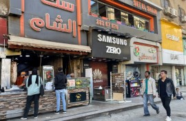 People pass a Syrian restaurant in western Cairo, where Syrian businesses have clustered, and the air buzzed with celebration after the fall of Bashar al-Assad in Damascus
