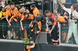 Lando Norris celebrates with the McLaren crew after winning the Abu Dhabi Grand Prix to seal the constructors' title