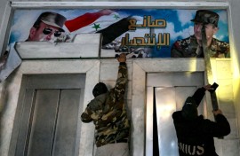 Posters of ousted president Bashar al-Assad and his father Hafez are torn down from the detention centre's upper-floor offices