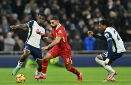 Liverpool star Mohamed Salah (C) bursts between  Yves Bissouma (L) and Djed Spence of Tottenham Hotspur during a  Premier League match in London on December 22, 2024.
