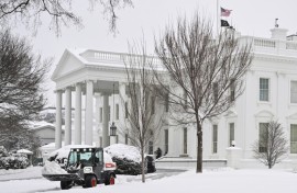 Workers remove snow outside the White House in Washington