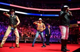 Trump looks on as the Village People perform at the MAGA victory rally at the Capital One Arena in Washington