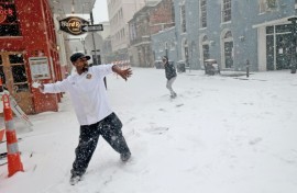 Sous chef Eric Walker engages in a snowball fight outside the Bourbon House Restaurant in the French Quarter in New Orleans, Louisiana, where a rare snow storm hammered the southern US city