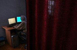 A woman is seen in November 2021 working at Kabul's Radio Begum, a women's radio station that has been raided by Afghanistan's Taliban authorities