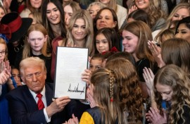 US President Donald Trump holds up a newly signed executive order that seeks to ban transgender female athletes from participating in women's sports