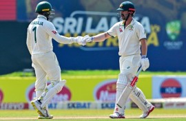Australia's Usman Khawaja (left) and teammate Travis Head bump fists on the fourth day of the second Test against Sri Lanka in Galle
