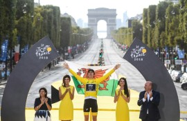 Geraint Thomas holds the Welsh flag aloft after his 2018 Tour de France triumph