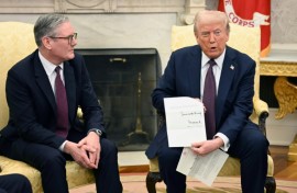 Donald Trump holds a letter from Britain's King Charles III during a bilateral meeting with British Prime Minister Keir Starmer in the Oval Office 