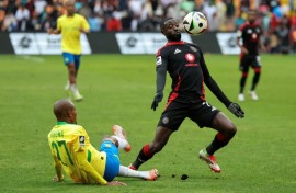 Deon Hotto (R) controls the ball watched by fallen Khuliso Mudau of Mamelodi Sundowns during a South African Premiership match in Johannesburg on March 16, 2025.

