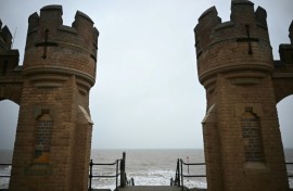 View of the North Sea between the turrets of the entrance to the old pier in Withernsea, on the east coast of England near where a collision between a tanker and a cargo ship caused multiple explosions