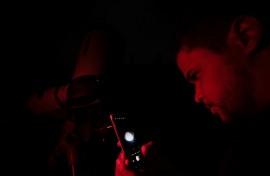 A man photographs the 'blood moon' with his phone through a telescope in Belo Horizonte, Brazil on March 14, 2025