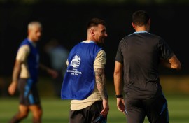 Lionel Messi (C) talks with Argentina head coach Lionel Scaloni (R) 