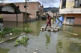 Rafael Quispe steers a makeshift raft through what used to be the streets of his village in western Bolivia