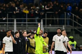 Germany goalkeeper Oliver Baumann celebrates with team-mates after winning the Nations League quarter-final first leg against Italy in Milan