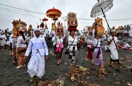 Hindu devotees take offerings to a beach near Denpasar