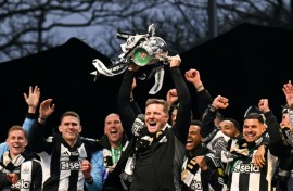 Newcastle manager Eddie Howe lifts the League Cup in front of a crowd of 150,000 celebrating fans