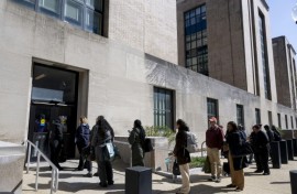 Federal workers wait in line to access to the Mary E. Switzer Memorial Building that houses the US Department of Health and Human Services in Washington, DC