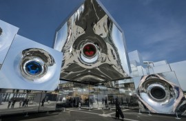 A woman (R) walks into the "null²" pavilion at the 2025 Osaka Expo