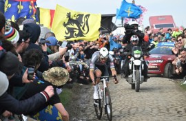 A liquid is spilled as Mathieu van der Poel battles past on the cobbles of Paris-Roubaix