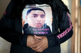"Your wife is looking for you" reads a message worn by Rubi Cruz, whose husband is one of more than 120,000 people missing in Mexico
