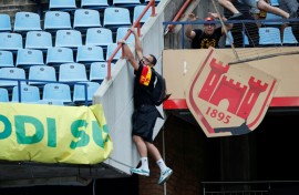 An Esperance supporter clings to a railing at a Pretoria stadium during crowd violence after a CAF Champions League match against Mamelodi Sundowns on April 1.