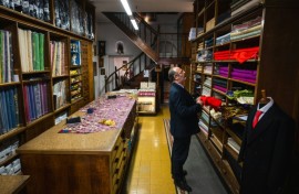 The shop's shelves are heavy with colourful bolts of fabric.