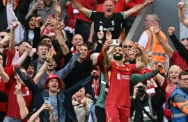 Liverpool forward Mohamed Salah takes a selfie with fans after scoring their fourth goal against Tottenham