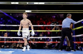 Undisputed super bantamweight champion Naoya Inoue of Japan, at left, walks away as referee Thomas Taylor stops the fight against American Ramon Cardenas in the eighth round