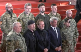 Bono, The Edge and US actor Sean Penn pose with Ukrainian soldiers on the Cannes red carpet