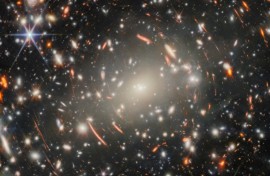 The new image uses a massive galaxy cluster as a magnifying glass to spy on ancient galaxies in the distance universe