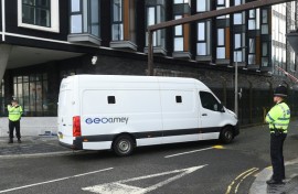 A prison van passes police officers outside Liverpool Magistrates' Court as a 53-year-old former Marine was due to appear for the first time facing seven charges of driving into crowds of football fans
