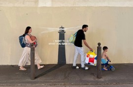 Pedestrians walk past a newly released artwork by street artist Banksy on the facade of a building in Marseille in southern France