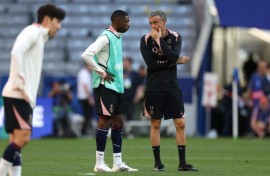Paris Saint-Germain coach Luis Enrique (R) speaks to Ousmane Dembele on the pitch at Munich's Allianz Arena on Friday