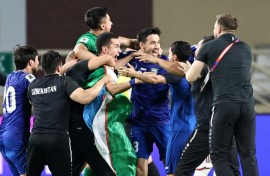 Uzbekistan's players celebrate after booking their berth in the FIFA World Cup for the first time with a draw against the United Arab Emirates in Abu Dhabi
