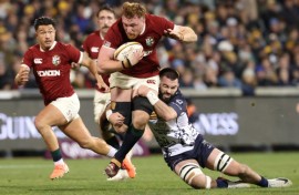 British and Irish Lions' Ollie Chessum (C) is tackled by ACT Brumbies' Luke Reimer