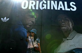 An Oasis fan takes a selfie in front of mural of the band's Gallagher brothers in their Manchester hometown