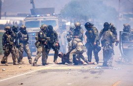 US Customs and Border Protection officers make an arrest after pulling a person out of their vehicle outside an immigation raid at Glass House Farms in Camarillo, California