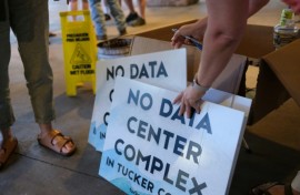 Volunteers hand out anti-data center signs at a public meeting in Canaan Valley, West Virginia, June 30, 2025