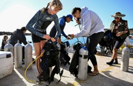 Divers from the environmental group Korero O Te Orau preparing their gear before collecting crown-of-thorns starfish from a reef off Rarotonga in the Cook Islands